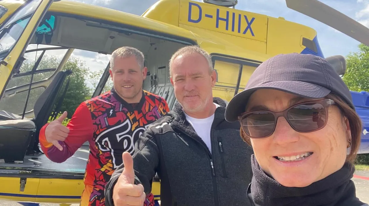 Das Team von Family of Sky vor dem Helikopter