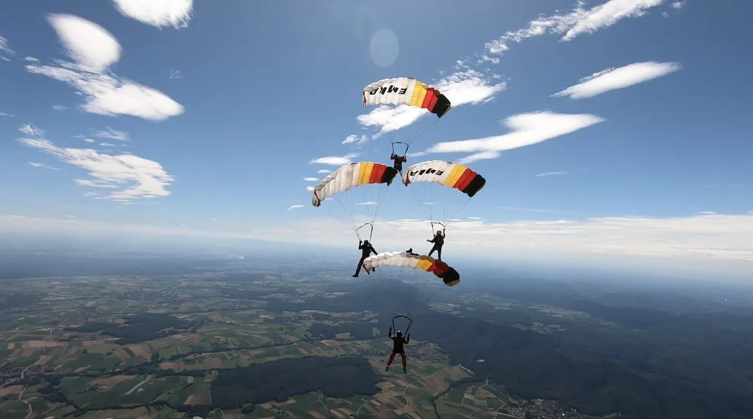 Mehrere Fallschirme über der Landschaft